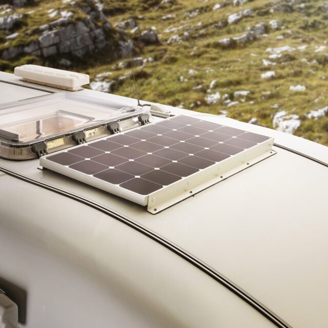 Dachansicht einer Wohnkabine mit integriertem Solarpanel – Gebirgskulisse im Hintergrund.