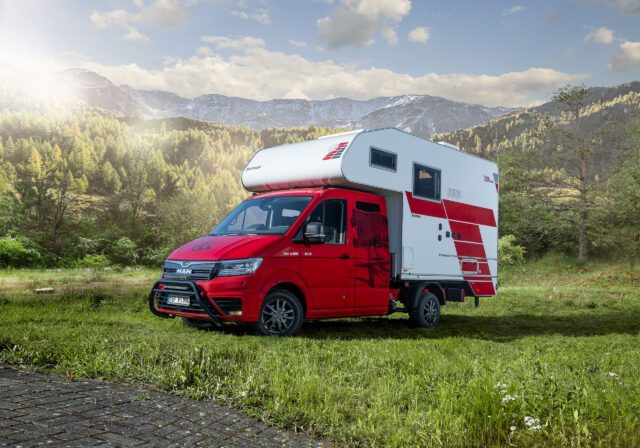 Außenansicht der Tischer Box 340S auf MAN TGE 3.180 mit rotem Fahrerhaus, seitliche Ansicht.