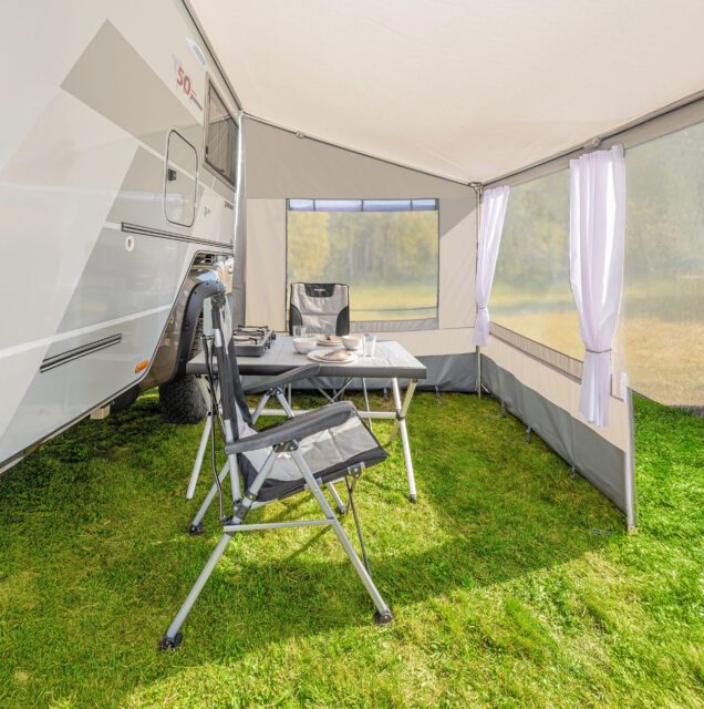 Innenansicht des aufgebauten Tischer Vorzelts mit zwei Stühlen, Tisch und Fensterwänden.