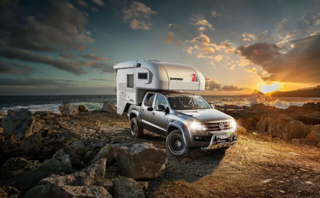 Tischer Trail Box 220 montiert auf VW Amarok, im Einsatz auf felsigem Gelände bei Sonnenuntergang.