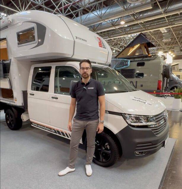 Tischer TRAIL Kabine auf VW Pick-Up, Mitarbeiter posiert daneben auf Messe.